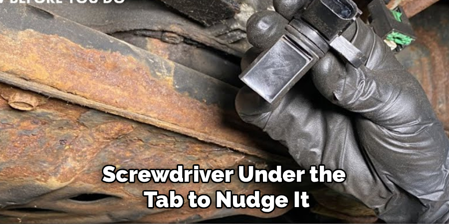 Screwdriver Under the
Tab to Nudge It